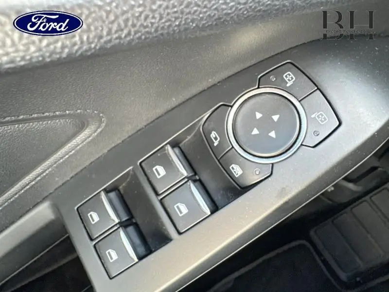 Gros plan sur les commandes des vitres et rétroviseurs côté conducteur de la Ford Focus Premium Rouge Candy 2020.