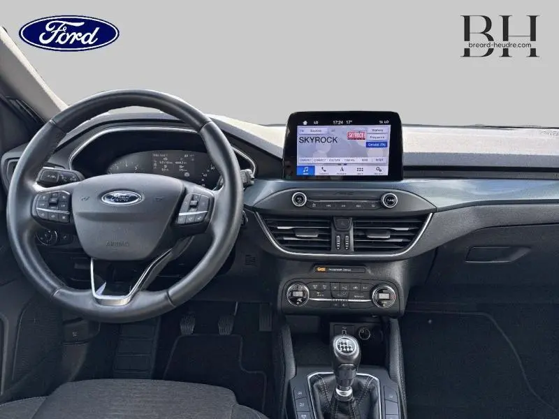 Vue intérieure avant de la Ford Focus 1.0 EcoBoost 2020, tableau de bord noir avec écran tactile et volant cuir multifonction.