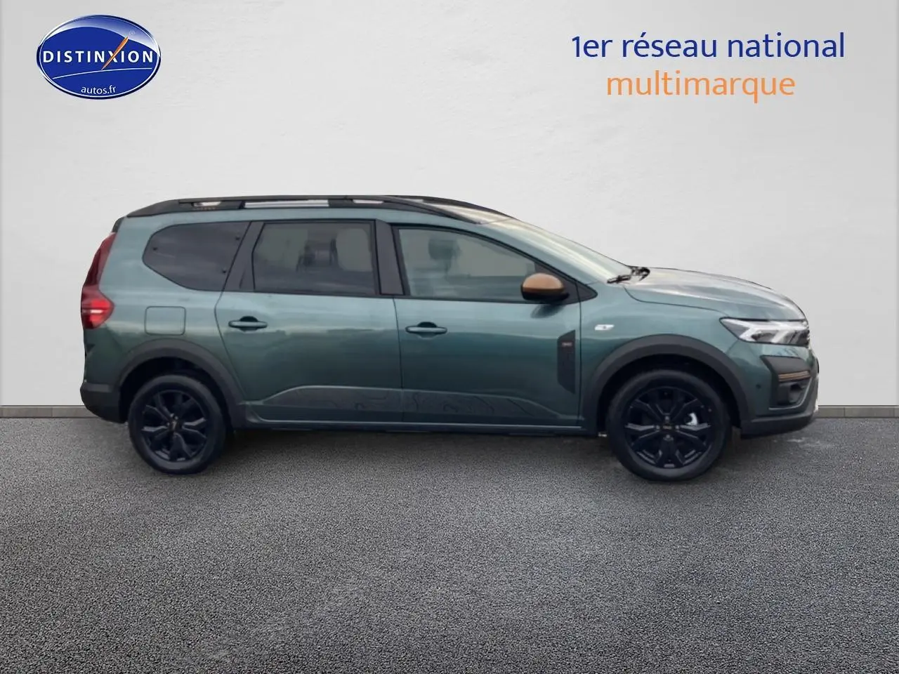 Vue de profil côté gauche d'un Dacia Jogger 2025 vert cèdre avec barres de toit et jantes noires.