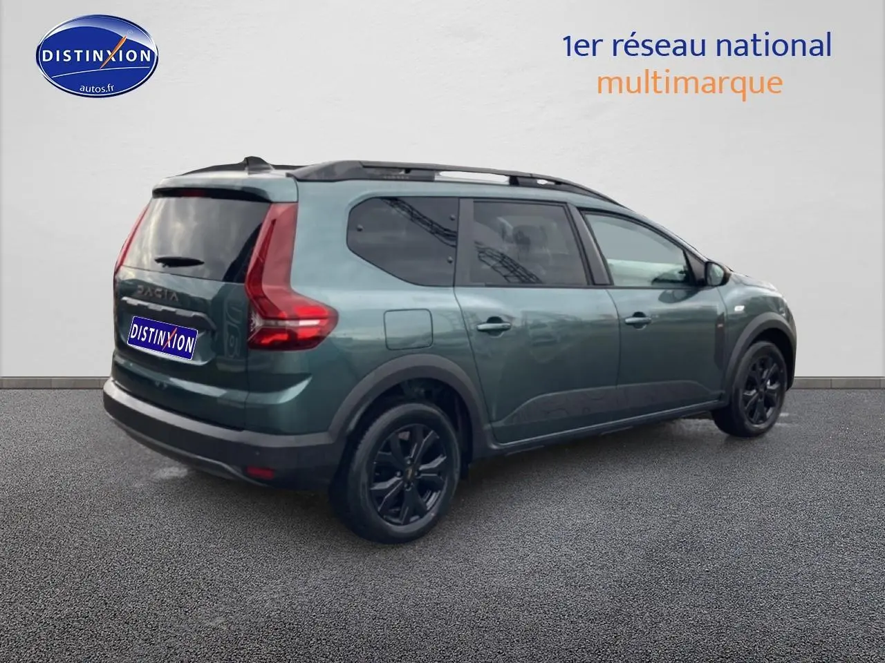 Vue 3/4 arrière droite du Dacia Jogger 2025 vert cèdre avec barres de toit et jantes noires.