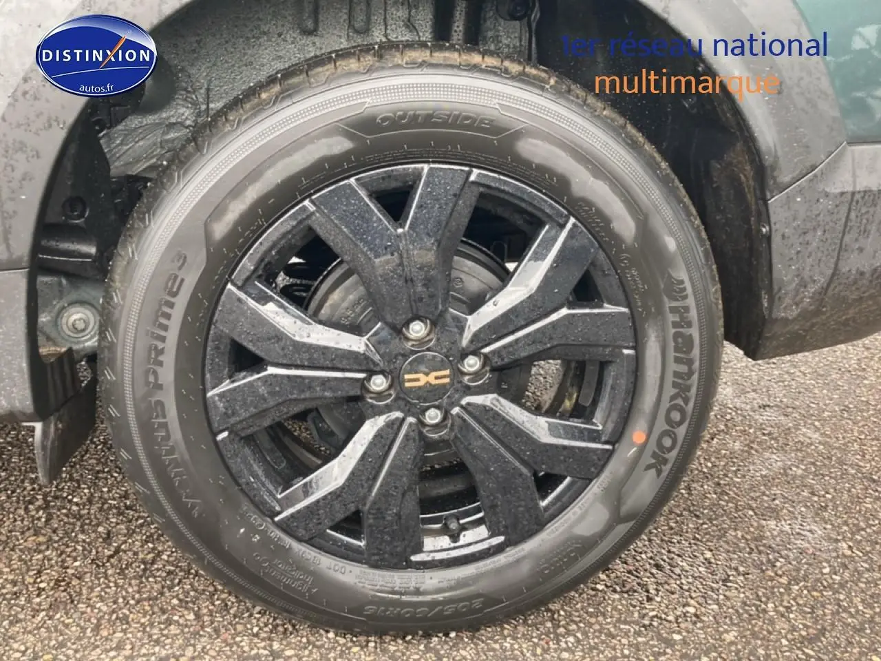 Gros plan sur la roue avant gauche du Dacia Jogger 2025 vert cèdre avec jante alu noire à design moderne.