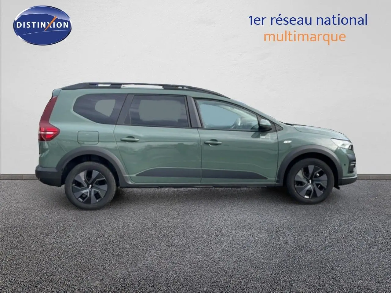 Vue latérale droite d'un Dacia Jogger gris schiste métal avec jantes noires et barres de toit noires.