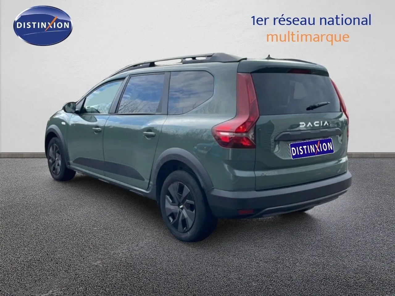 Vue 3/4 arrière gauche d'un Dacia Jogger gris schiste métal avec barres de toit et vitres teintées.