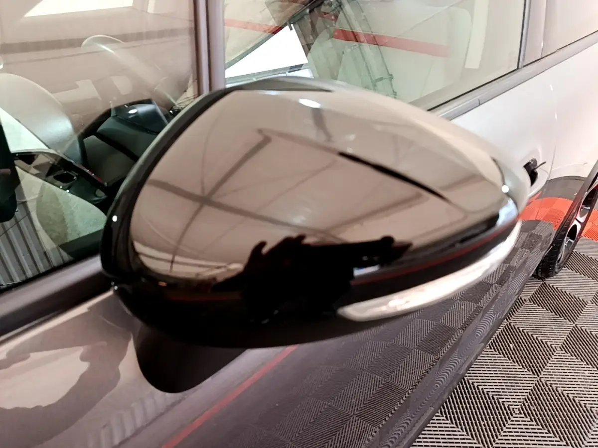 Rétroviseur droit noir brillant sur Citroën C3 Aircross gris foncé, vue rapprochée côté conducteur.
