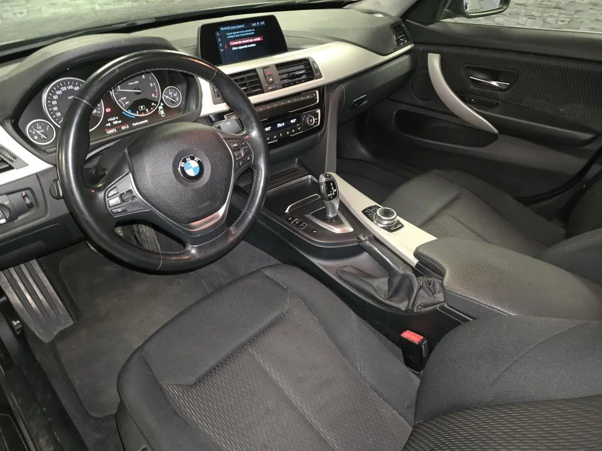 Vue intérieure côté conducteur de la BMW Série 4 420d Gran Coupé 2018 avec sellerie tissu anthracite et console centrale aluminium satiné.