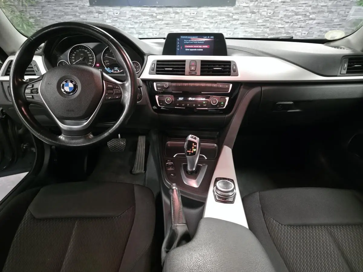 Vue intérieure frontale du poste de conduite de la BMW Série 4 420d Gran Coupé avec volant cuir et console centrale argentée.