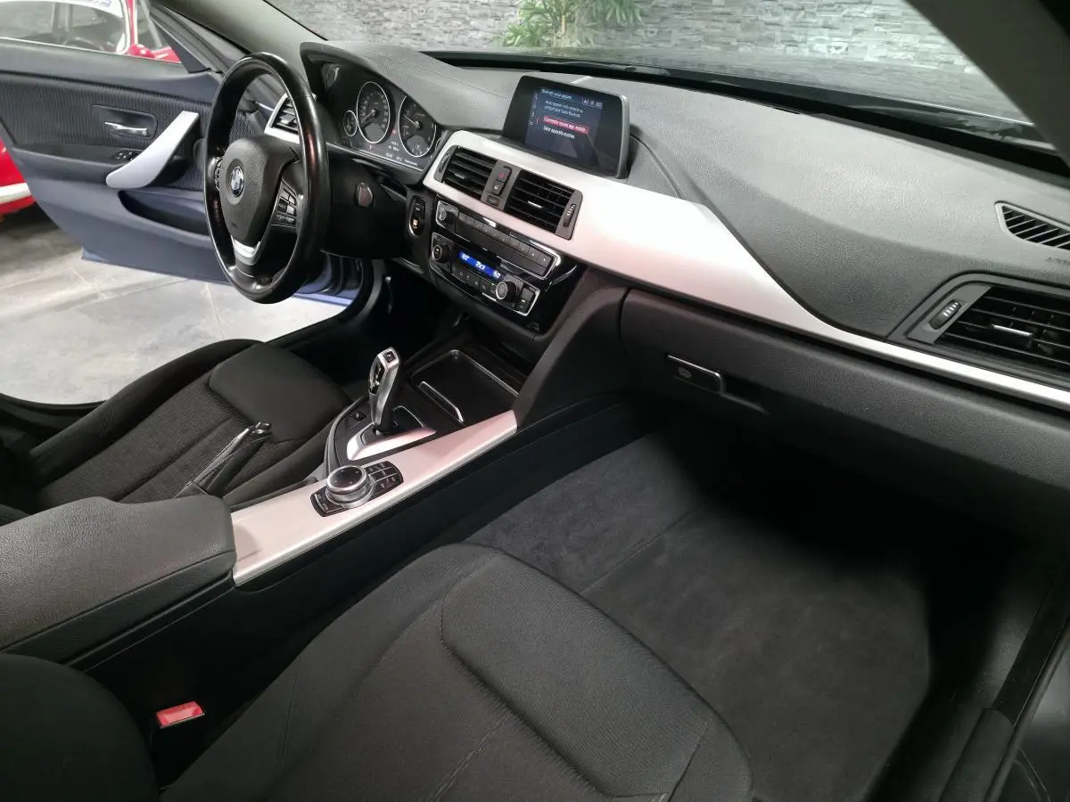 Vue intérieure côté conducteur de la BMW Série 4 Gran Coupé 420d, avec console centrale aluminium satiné et écran multimédia.