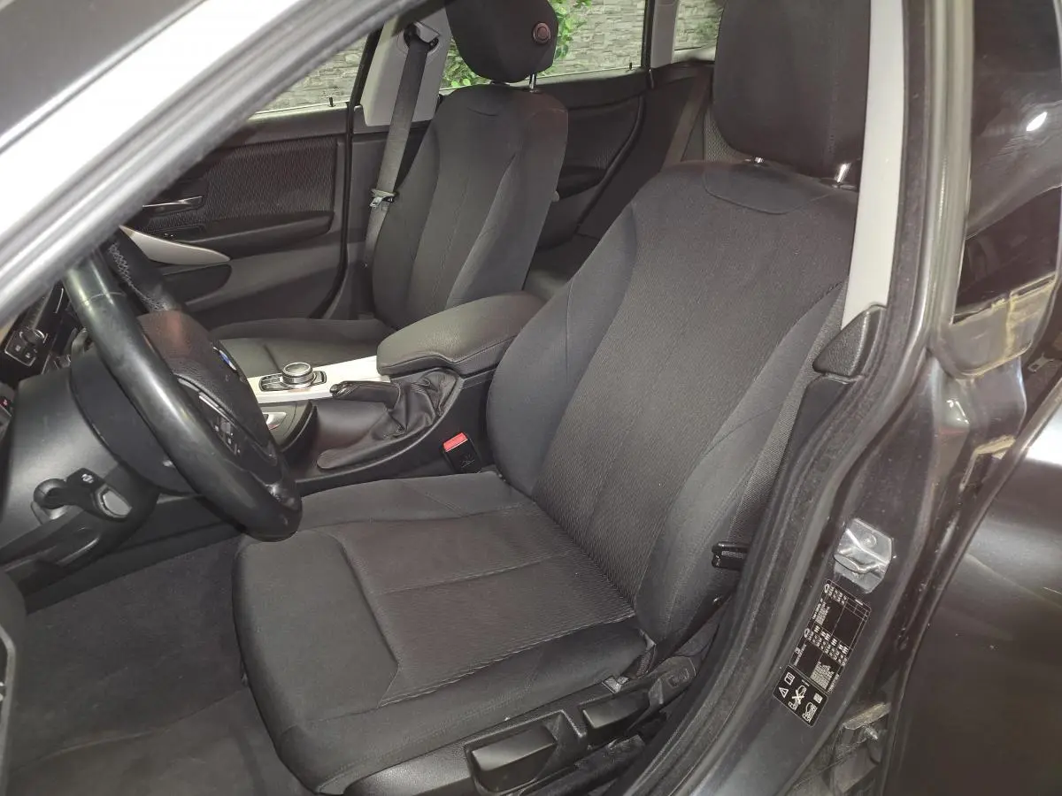 Vue intérieure côté conducteur de la BMW Série 4 Gran Coupé 420d gris foncé, sièges tissu anthracite et console centrale.