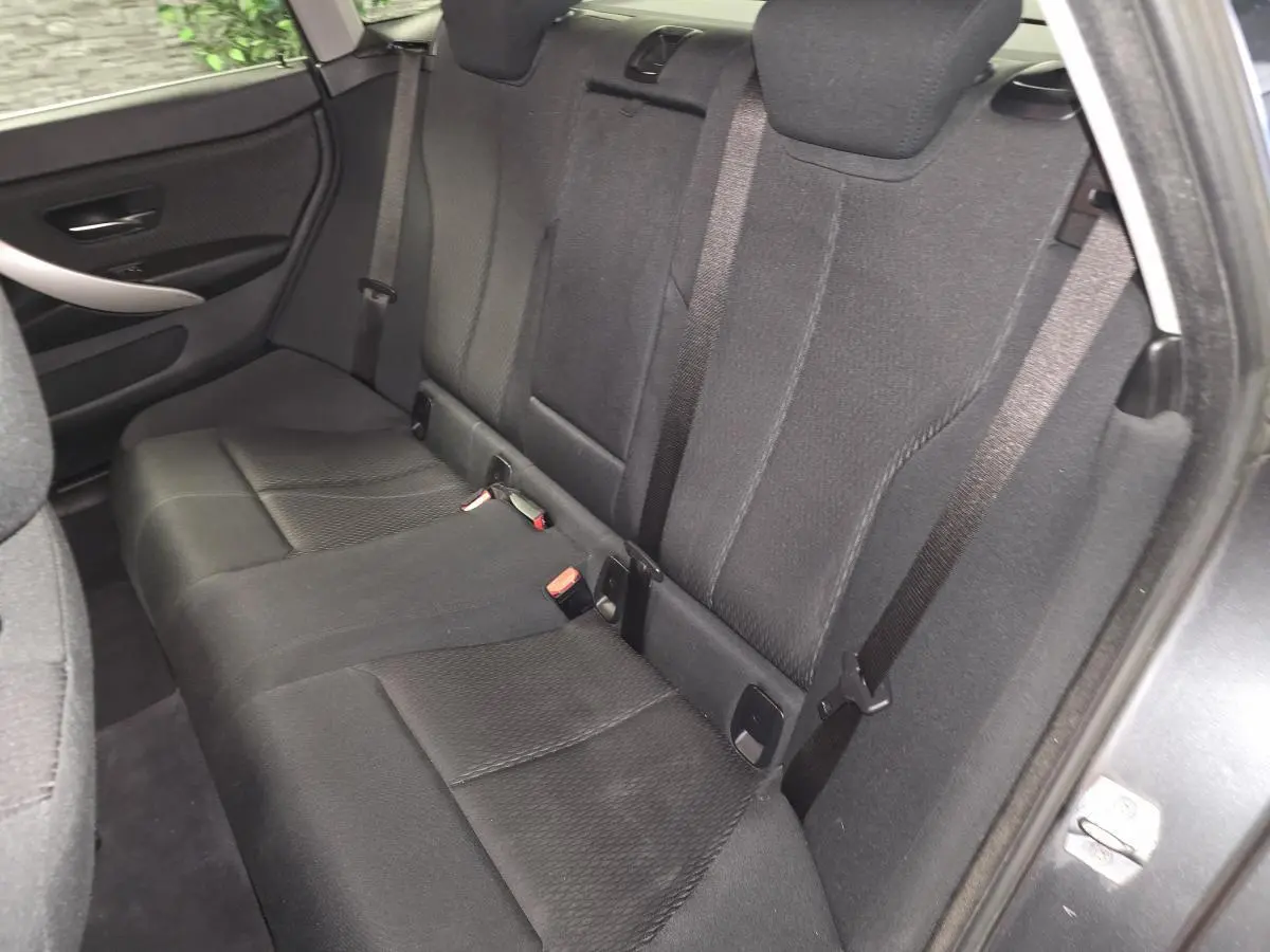 Banquette arrière en tissu anthracite vue côté droit de la BMW Série 4 Gran Coupé gris foncé avec ceintures de sécurité visibles.
