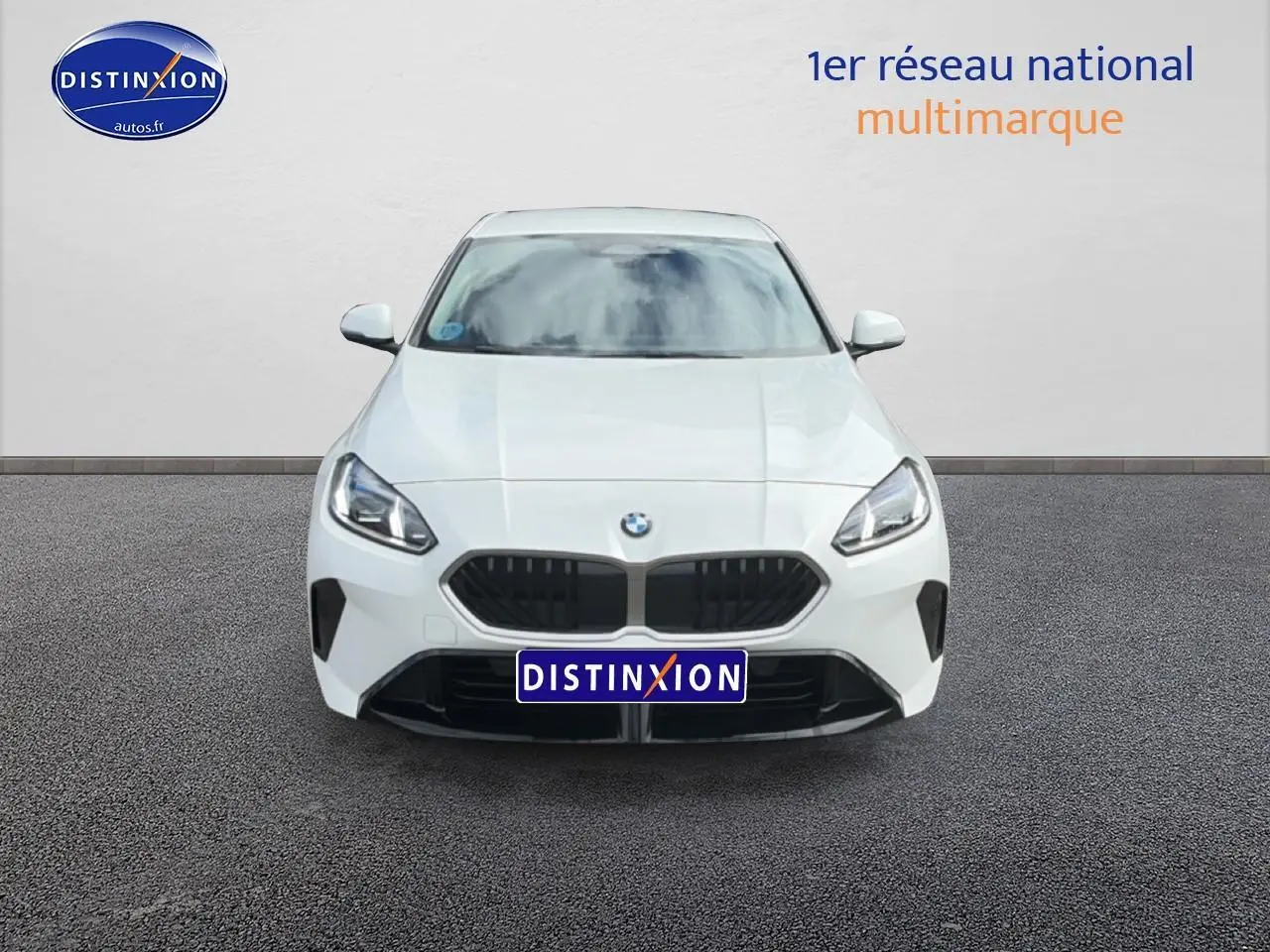 Vue avant frontale d'une BMW Série 1 blanche pure avec calandre noire et phares LED allumés.