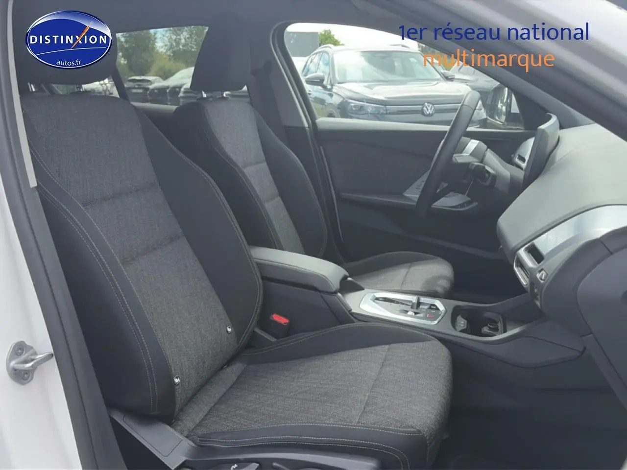 Vue intérieure côté conducteur de la BMW Série 1 blanche, montrant sièges sport et console centrale moderne.