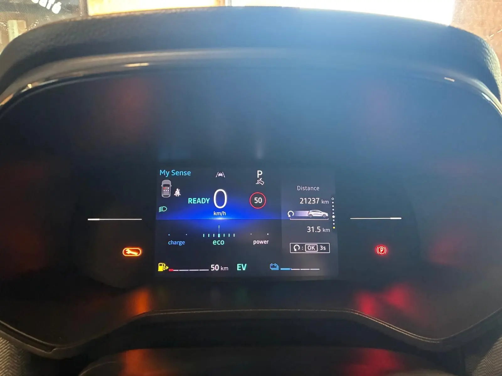 Tableau de bord numérique de Renault Clio V E-TECH 145, affichant vitesse, autonomie et indicateurs, vue frontale rapprochée.