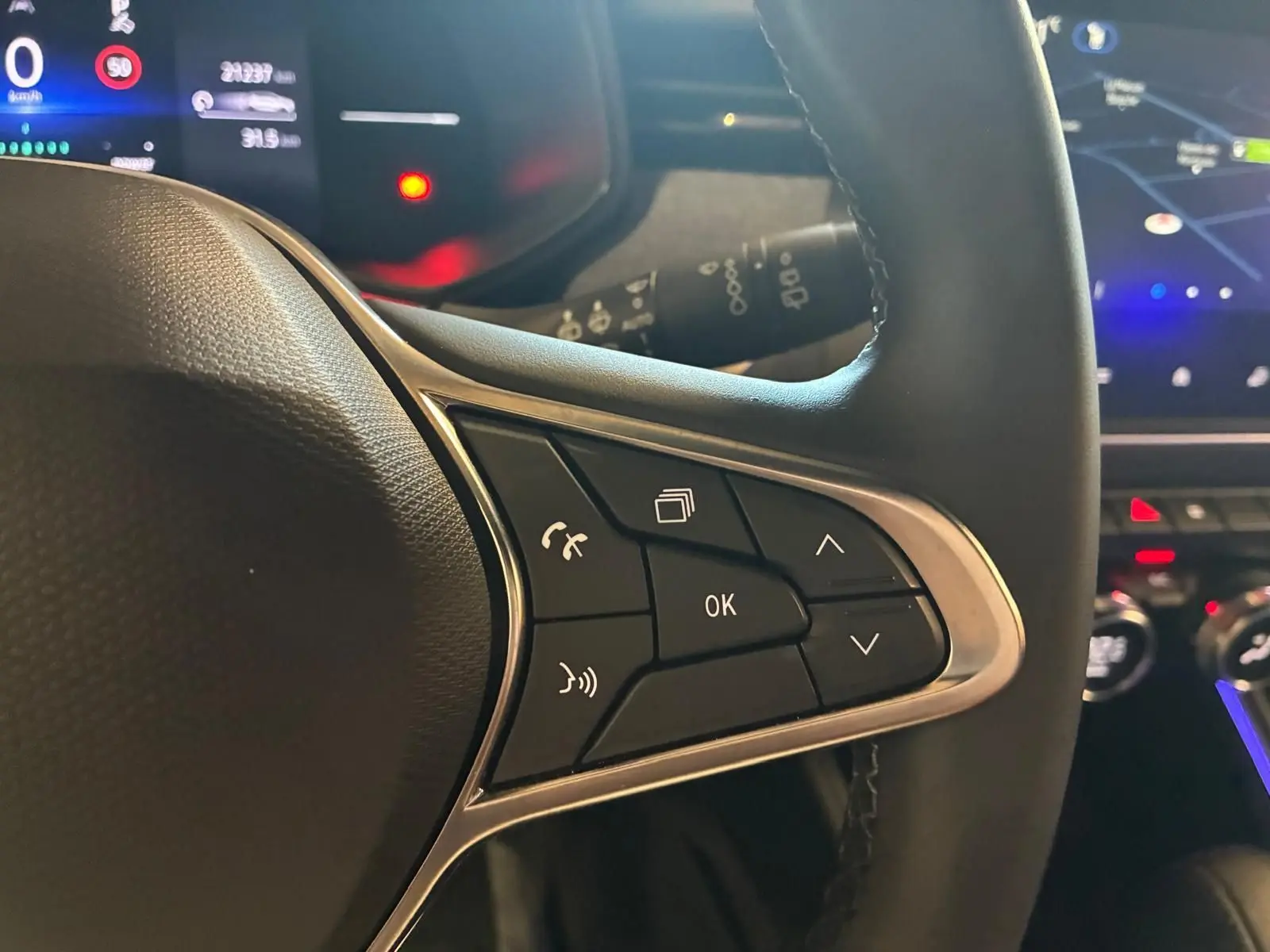 Gros plan sur les commandes multifonctions à droite du volant d’une Renault Clio V E-TECH 145 Techno, intérieur noir.