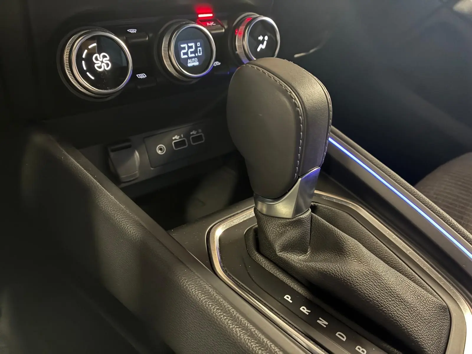 Gros plan sur le levier de vitesses automatique et les commandes de climatisation de la Renault Clio V E-TECH 145 TECHNO.