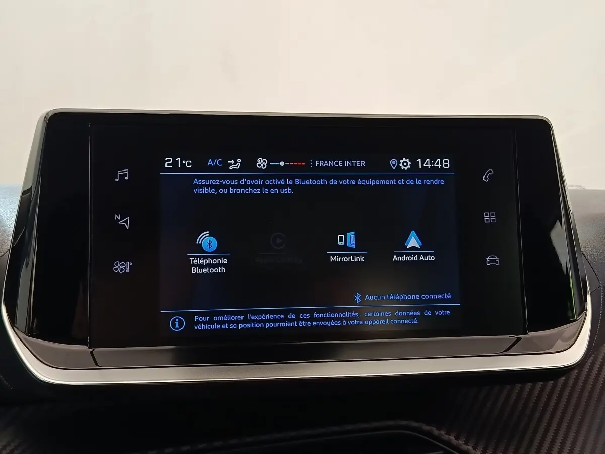 Écran tactile central de la Peugeot 208 blanc, affichant les options Bluetooth, MirrorLink et Android Auto.