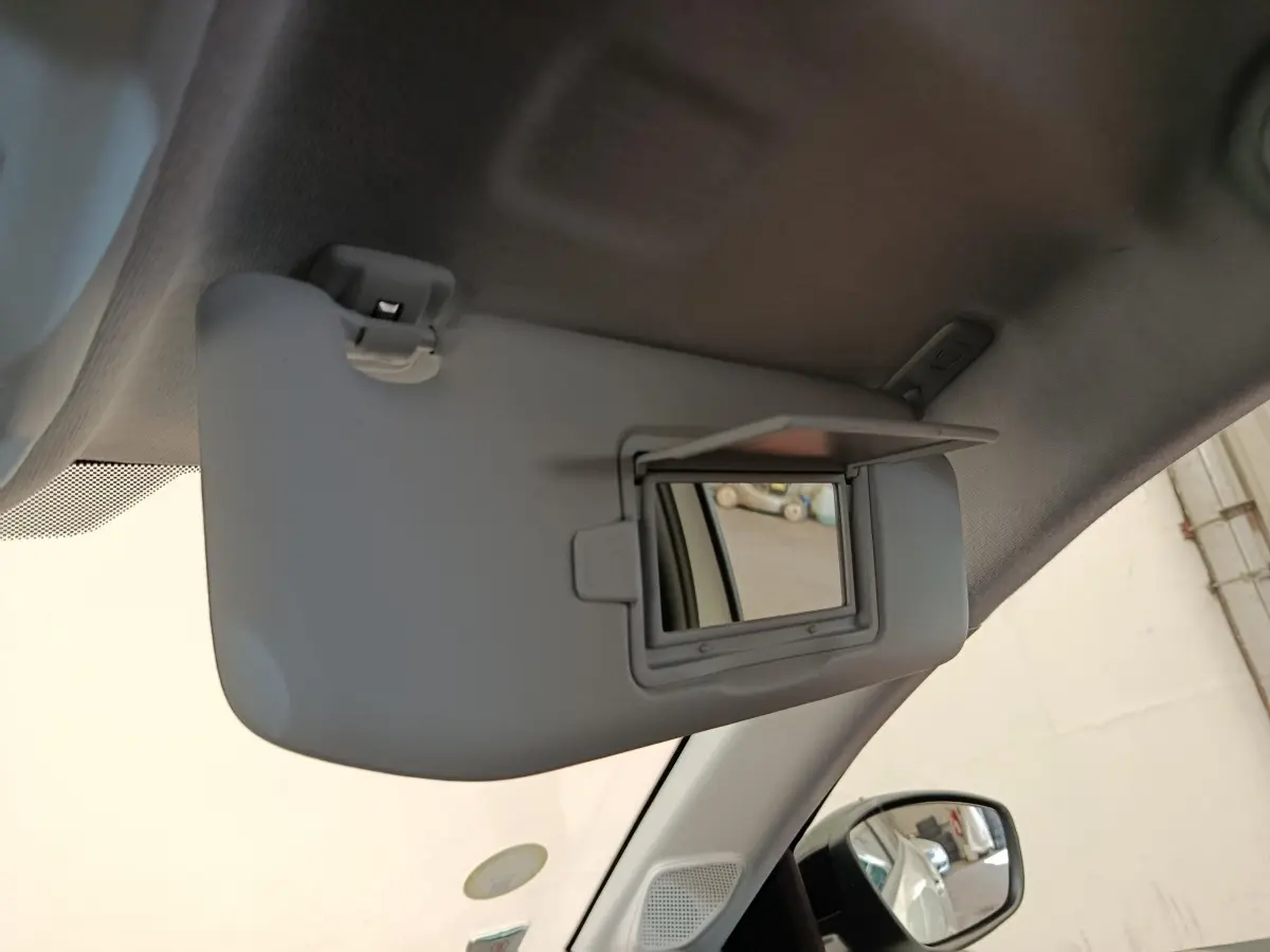 Miroir de courtoisie ouvert sur pare-soleil côté conducteur dans l’habitacle d’une Peugeot 208 blanche.