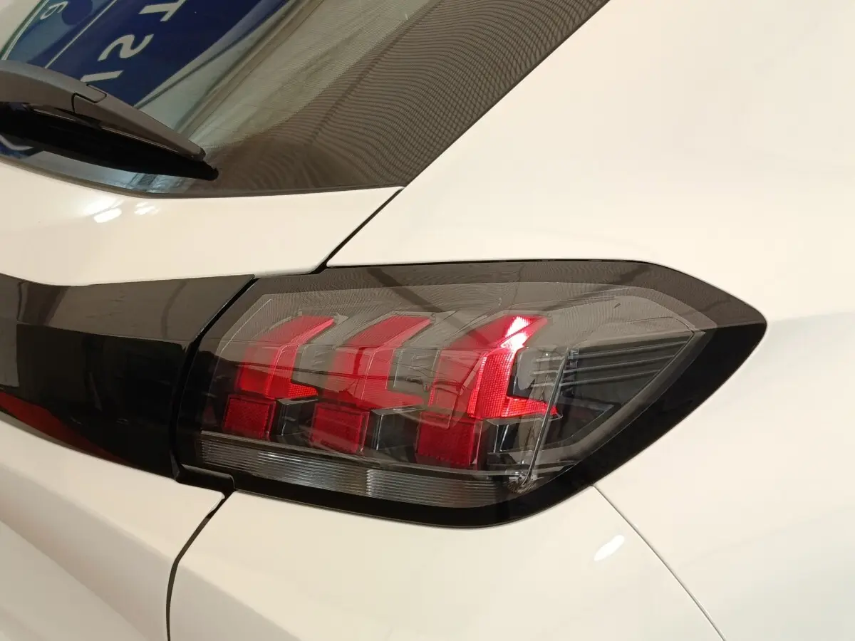 Gros plan sur le feu arrière droit rouge et noir d'une Peugeot 208 blanche, version BlueHDi 2022.