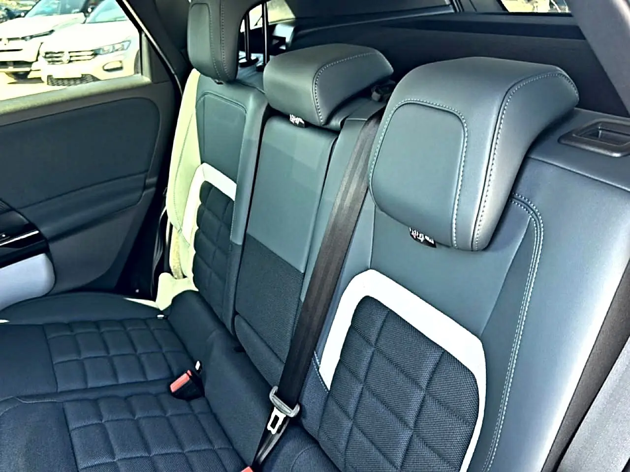 Vue intérieure sur la banquette arrière en cuir noir et gris du Citroën C5 Aircross hybride 2026.