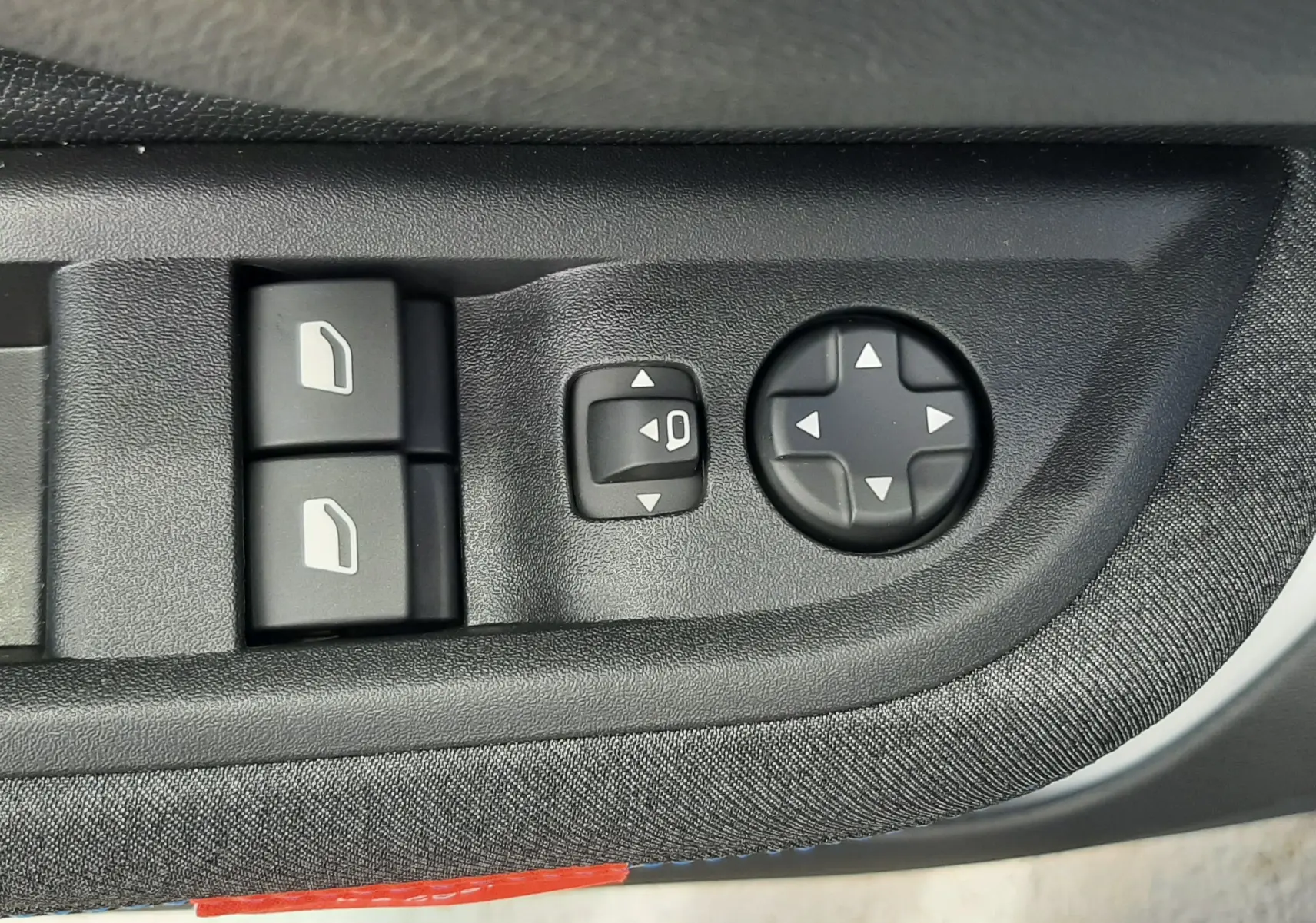 Gros plan sur les commandes de réglage des rétroviseurs et des vitres côté conducteur d'une Citroën C3 Turbo 100ch Plus 2026.
