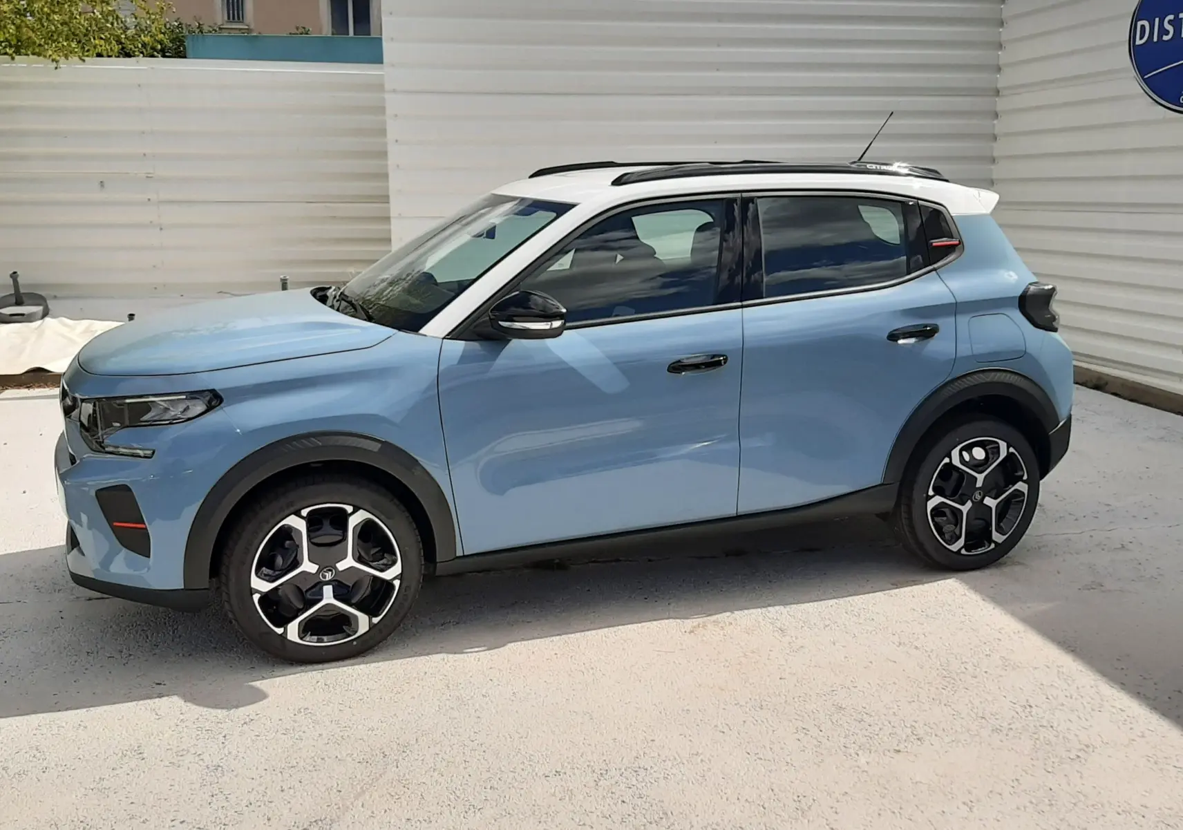 Citroën C3 Turbo 100ch Plus bleu Monte Carlo avec toit blanc, vue de profil côté gauche, roues distinctives noires et argent.