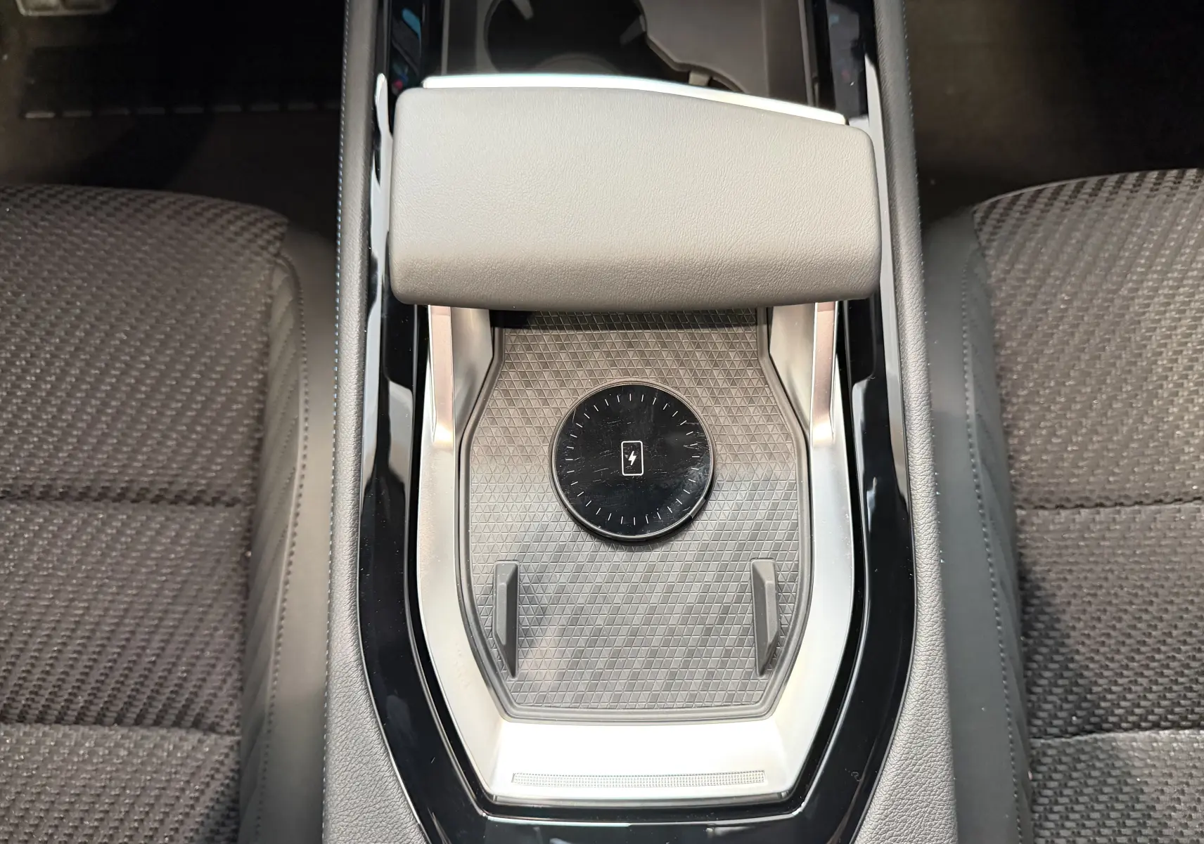 Vue plongeante sur la console centrale noire du Renault Austral E-Tech 200 Esprit Alpine avec tapis de recharge sans fil.