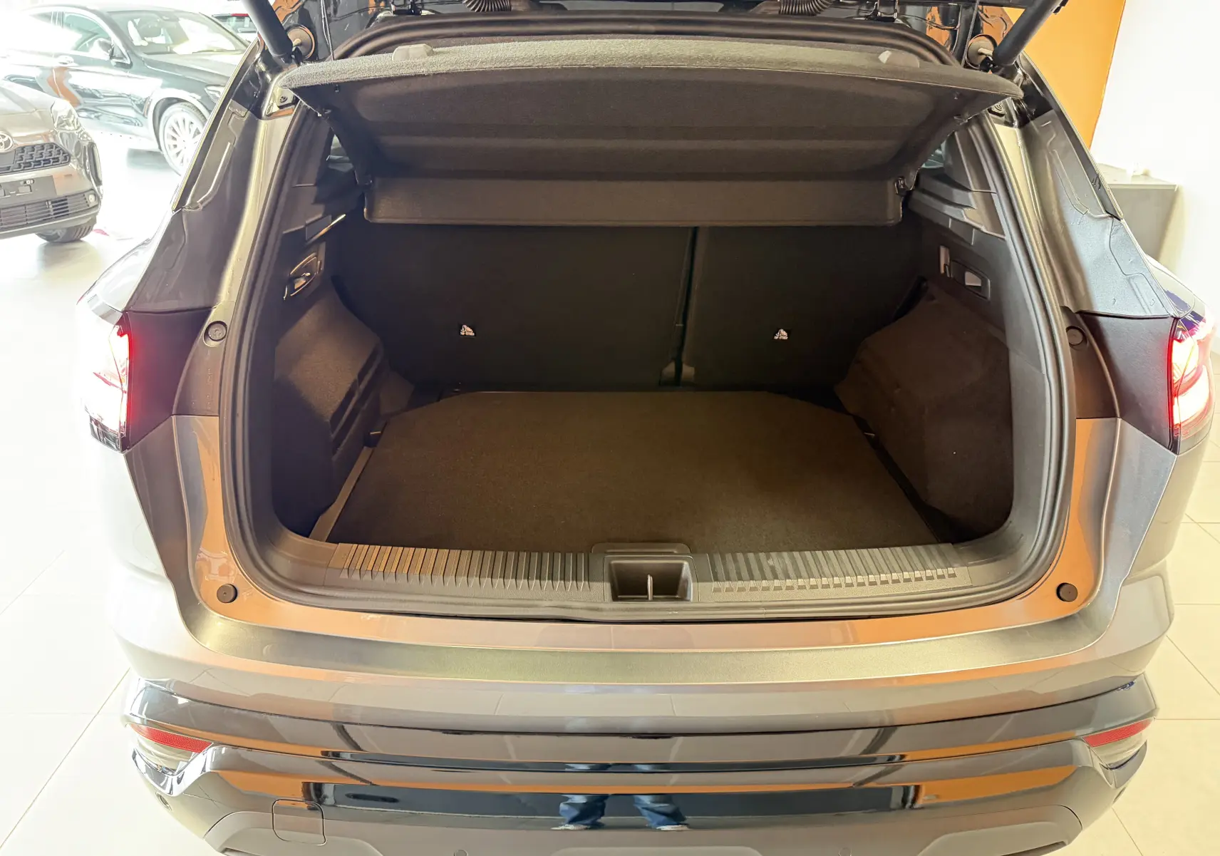 Vue arrière du coffre ouvert d'un Renault Austral E-Tech 200 Esprit Alpine gris schiste avec toit noir, intérieur noir.