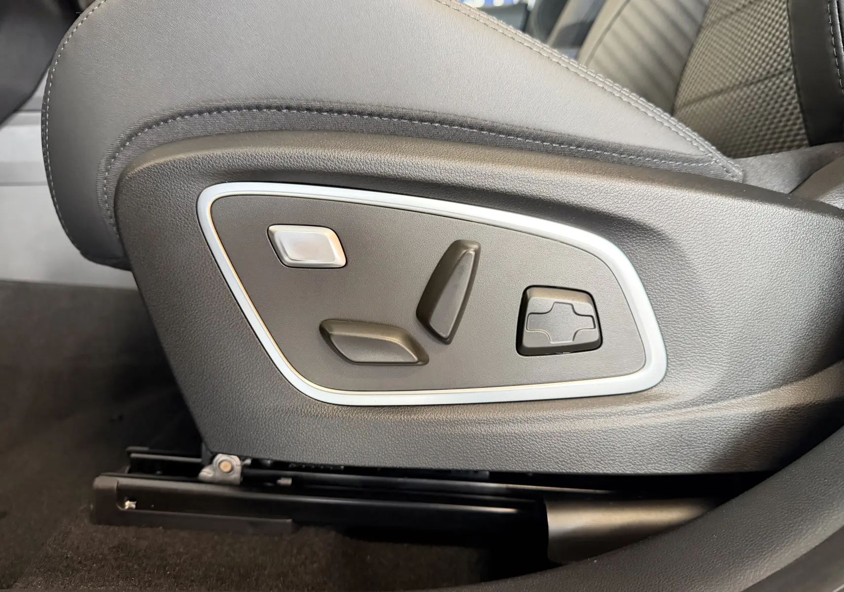 Gros plan sur les commandes électriques du siège avant en sellerie mixte noire du Renault Austral E-Tech 200 Esprit Alpine.