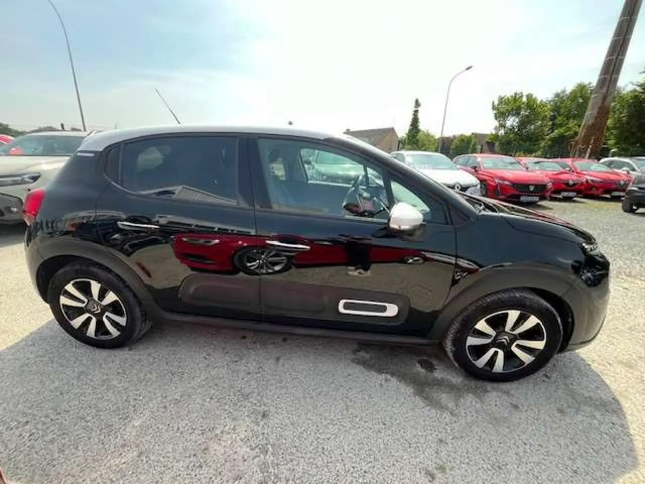 Profil côté gauche d'une Citroën C3 noire métal 2023 avec jantes alliage et rétroviseurs argentés.
