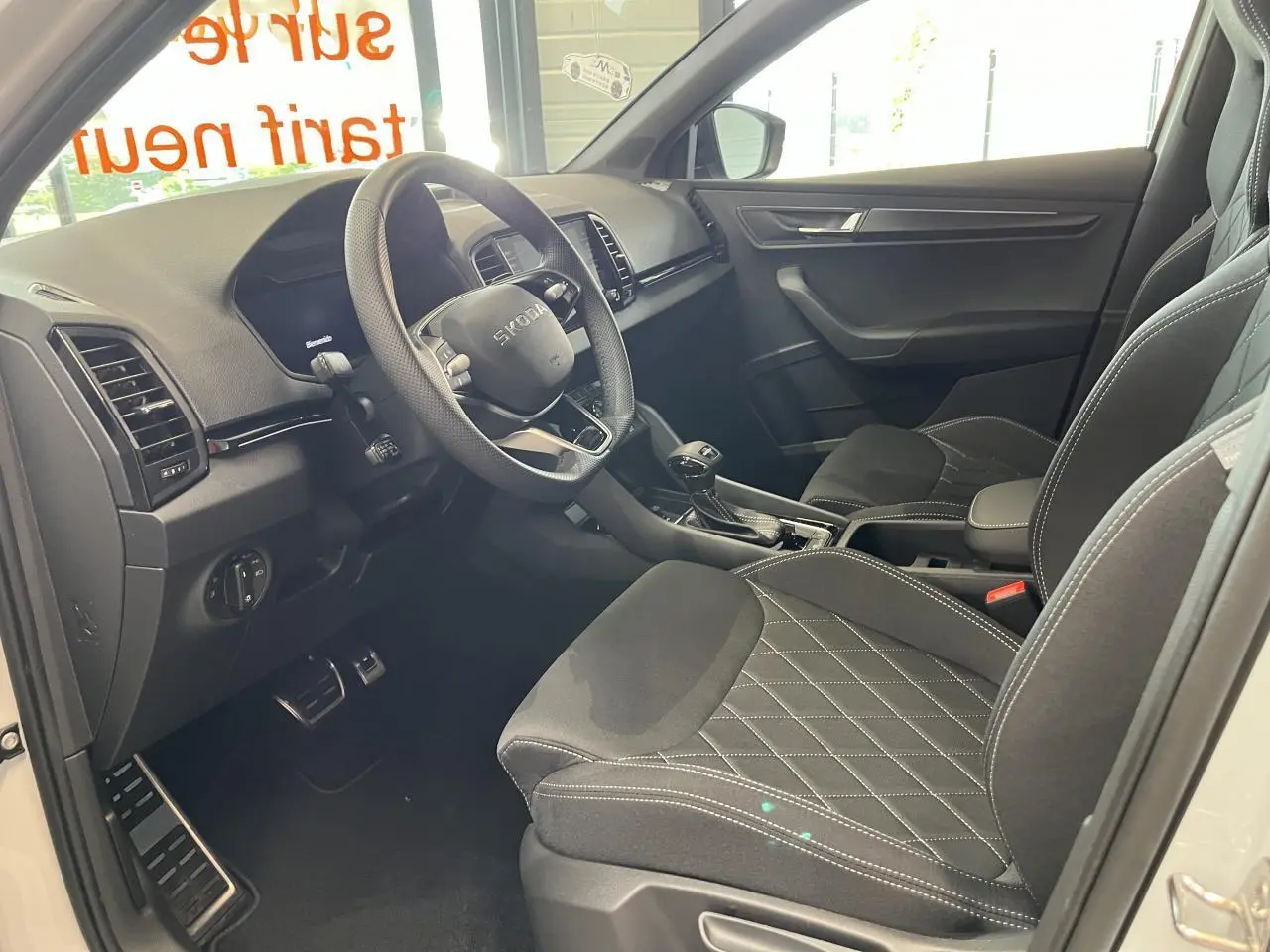 Intérieur noir du Skoda Karoq 2025 vu côté conducteur, avec sièges sport et volant multifonctions cuir.