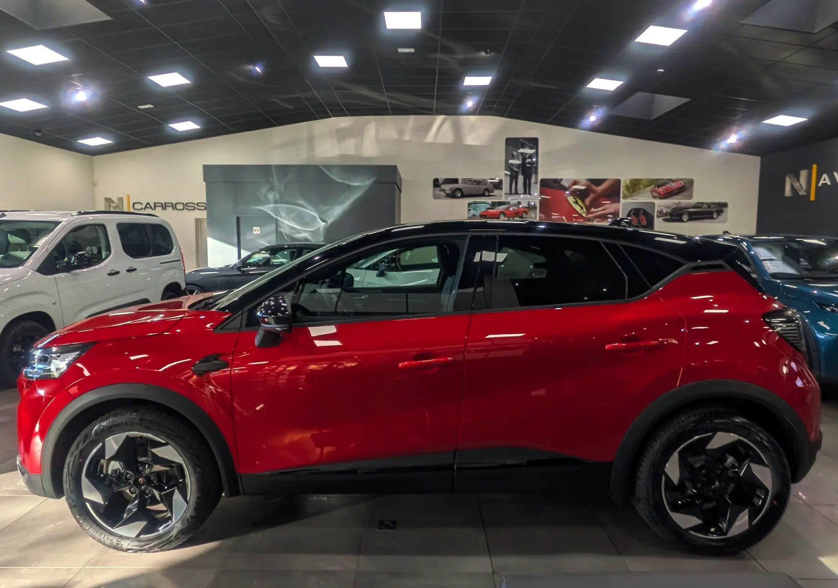 Profil latéral droit du Renault Captur E-TECH 2025 en Rouge Flamme avec toit noir et jantes noires bicolores.