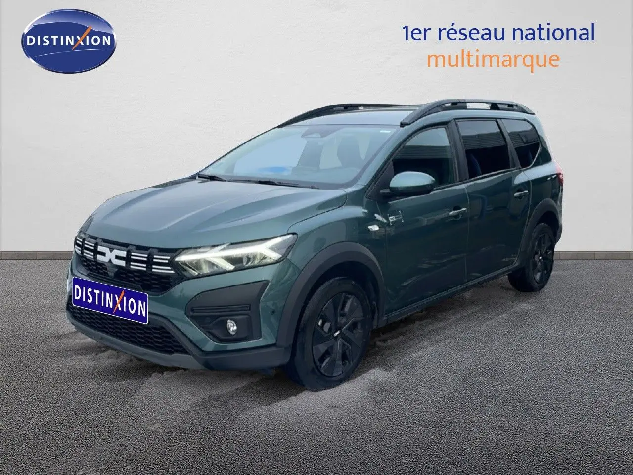 Dacia Jogger 2025 vert cèdre métal en 3/4 avant droit avec toit noir et jantes noires distinctives.