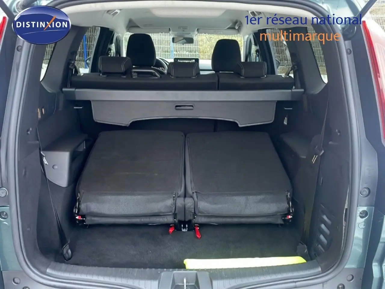Vue arrière du Dacia Jogger vert cèdre métal avec banquette arrière rabattue et coffre ouvert.