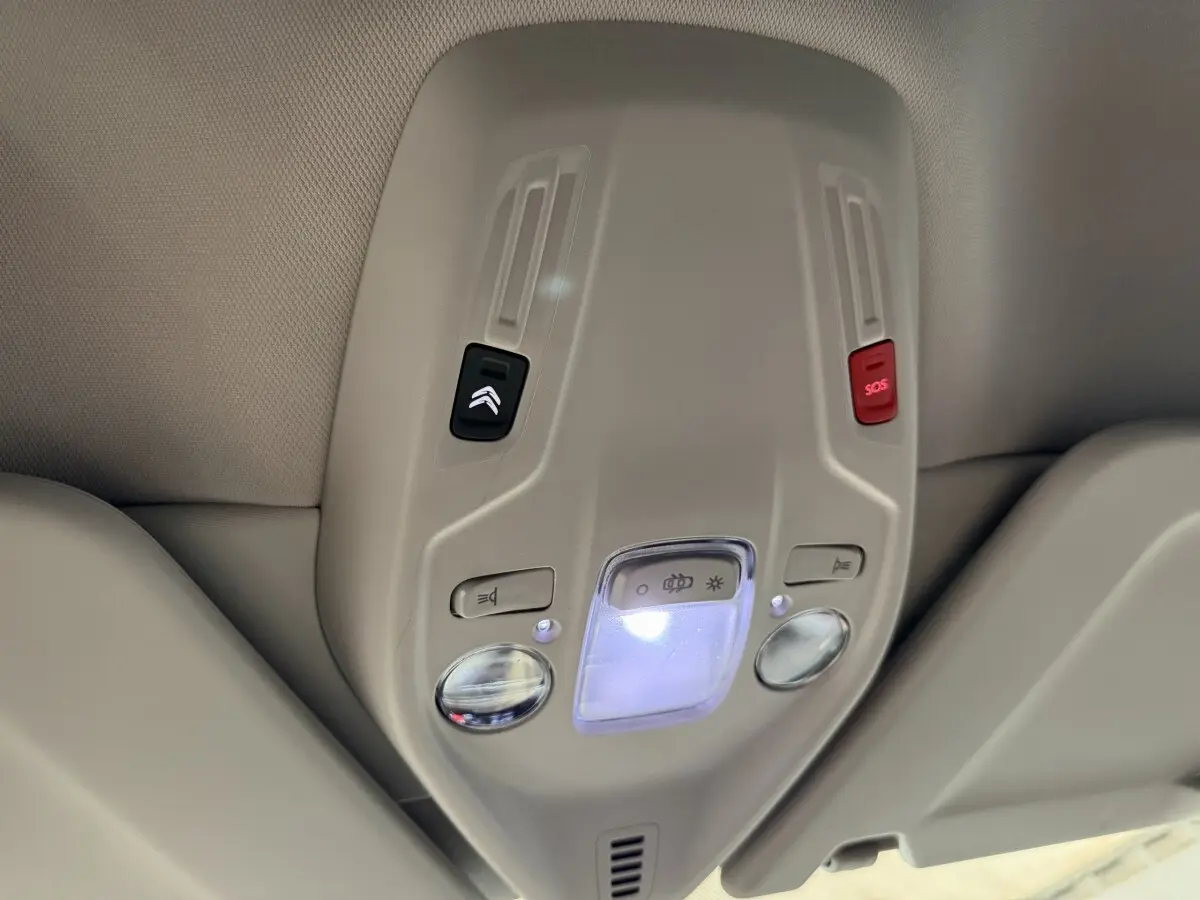 Plafonnier intérieur beige avec commandes d’éclairage et bouton SOS dans un Citroën C4 Spacetourer noir, vue de dessous.