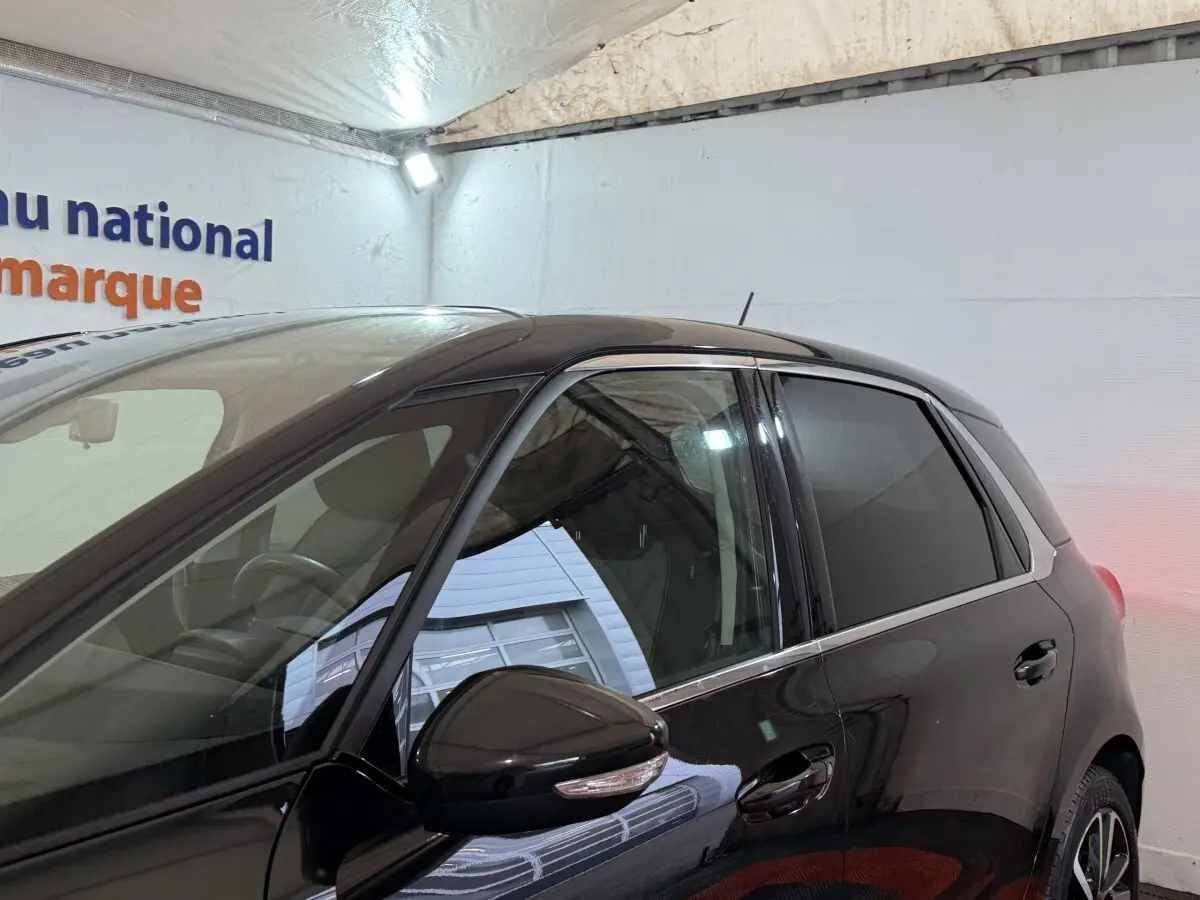 Vue latérale gauche d'une Citroën C4 Spacetourer noire 2020 avec rétroviseur et vitres teintées visibles.