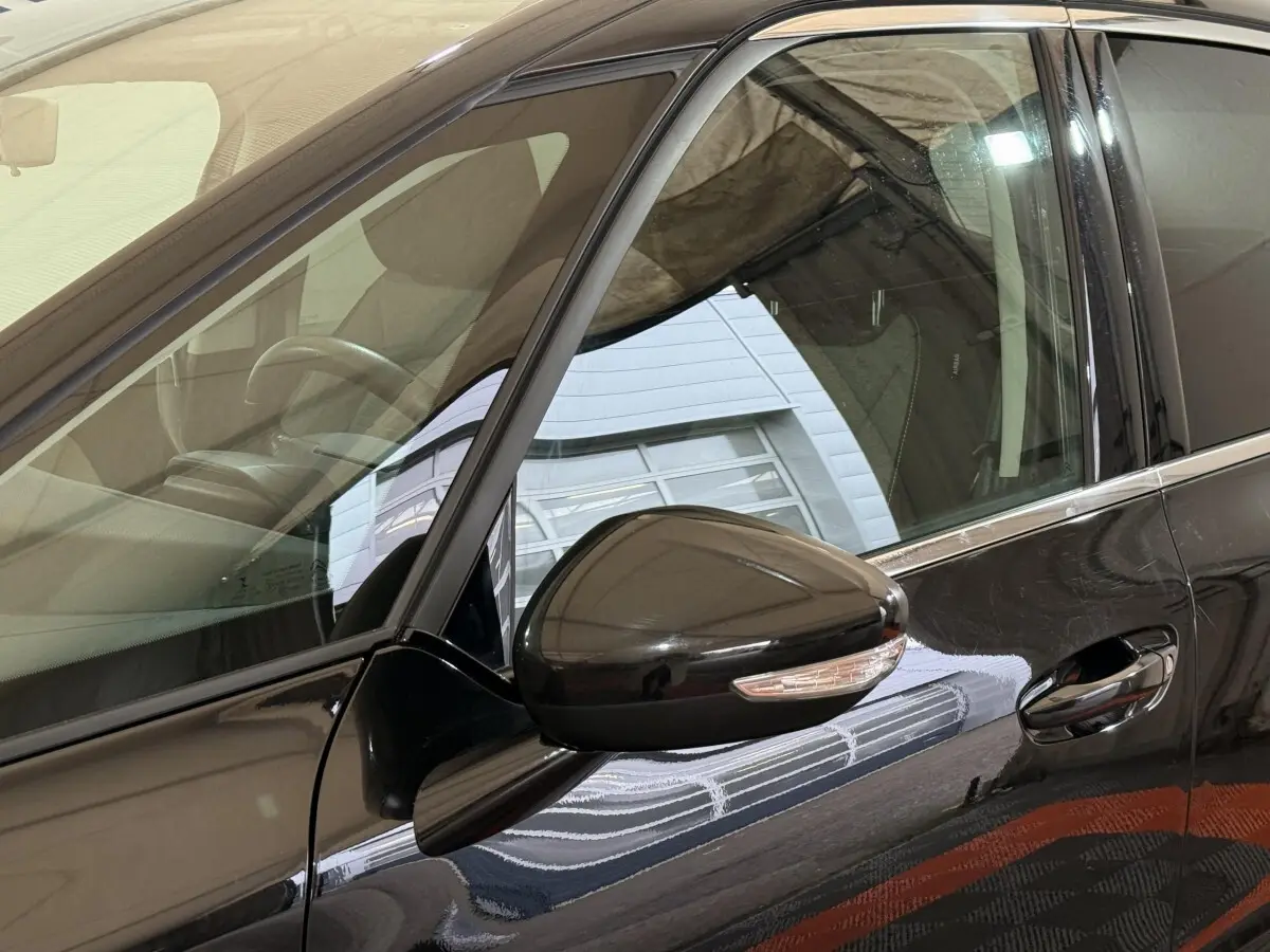 Vue rapprochée du rétroviseur et de la porte côté conducteur d'une Citroën C4 Spacetourer noire brillante.