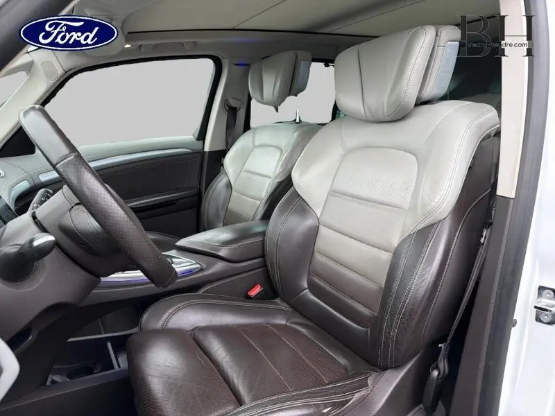 Vue intérieure côté conducteur du Renault Espace 2015 avec sièges en cuir bicolore gris clair et marron foncé.