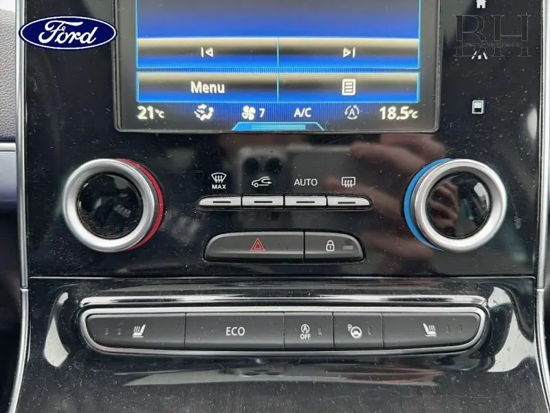 Gros plan sur la console centrale noire du Renault Espace blanc, avec commandes climatisation et écran tactile visible.