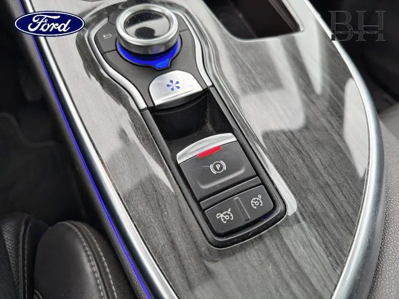 Console centrale en bois gris avec commandes électroniques et éclairage bleu intérieur, vue rapprochée côté droit.