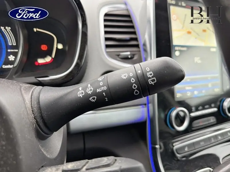 Gros plan sur la commande d’essuie-glace côté gauche du tableau de bord d’un Ford avec écran tactile et éclairage bleu.