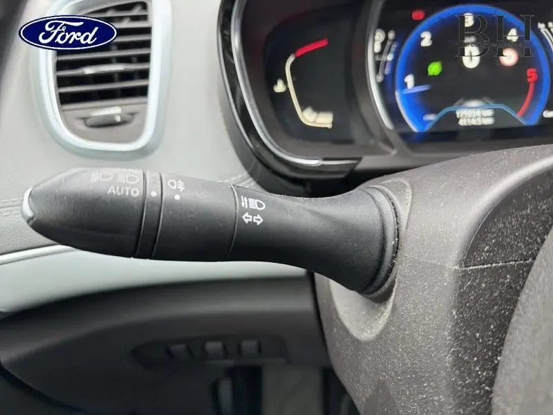 Gros plan sur la manette de clignotant noire à gauche du volant dans l'habitacle d'un Renault Espace blanc Glacier.