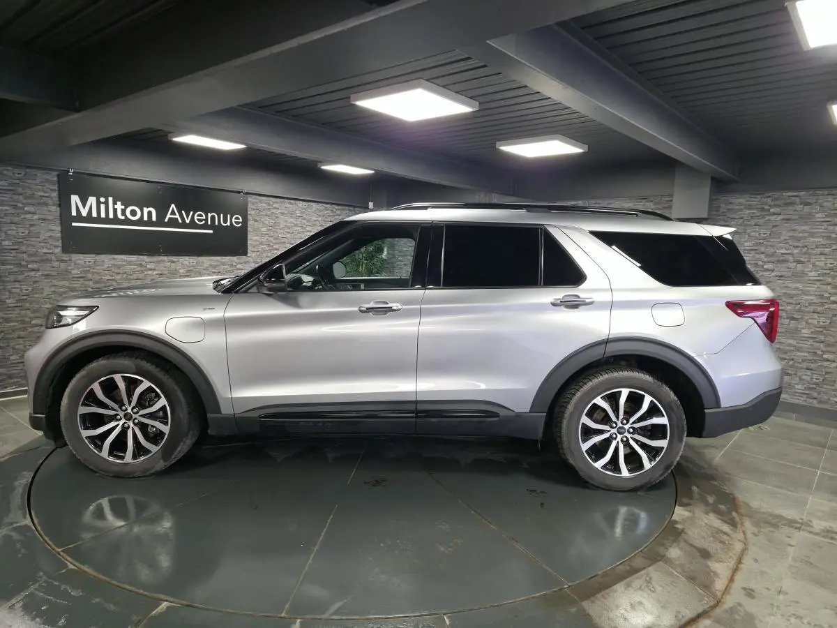 Vue de profil côté gauche du Ford Explorer gris métallisé hybride rechargeable avec jantes alliage et toit noir.