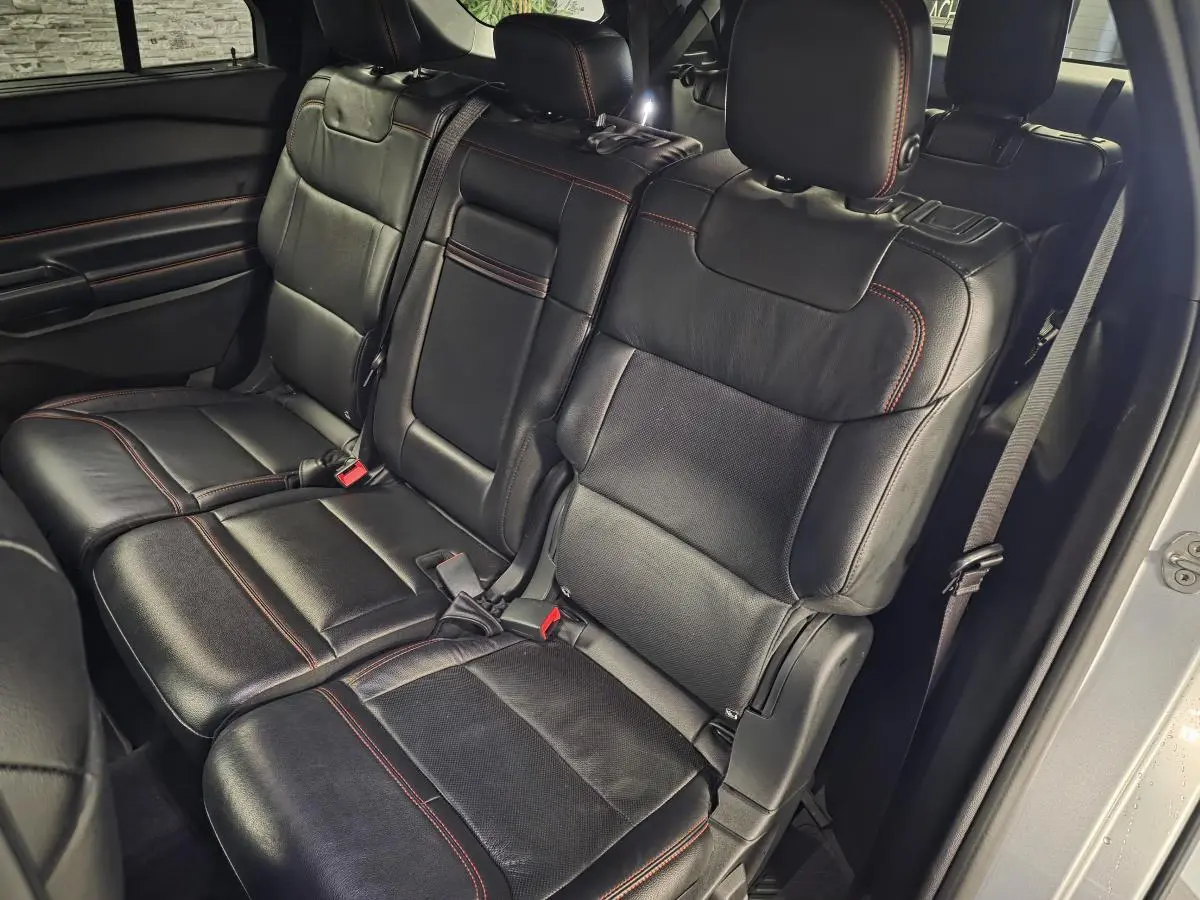 Vue intérieure côté droit sur la banquette arrière en cuir noir avec surpiqûres rouges du Ford Explorer gris 2020.