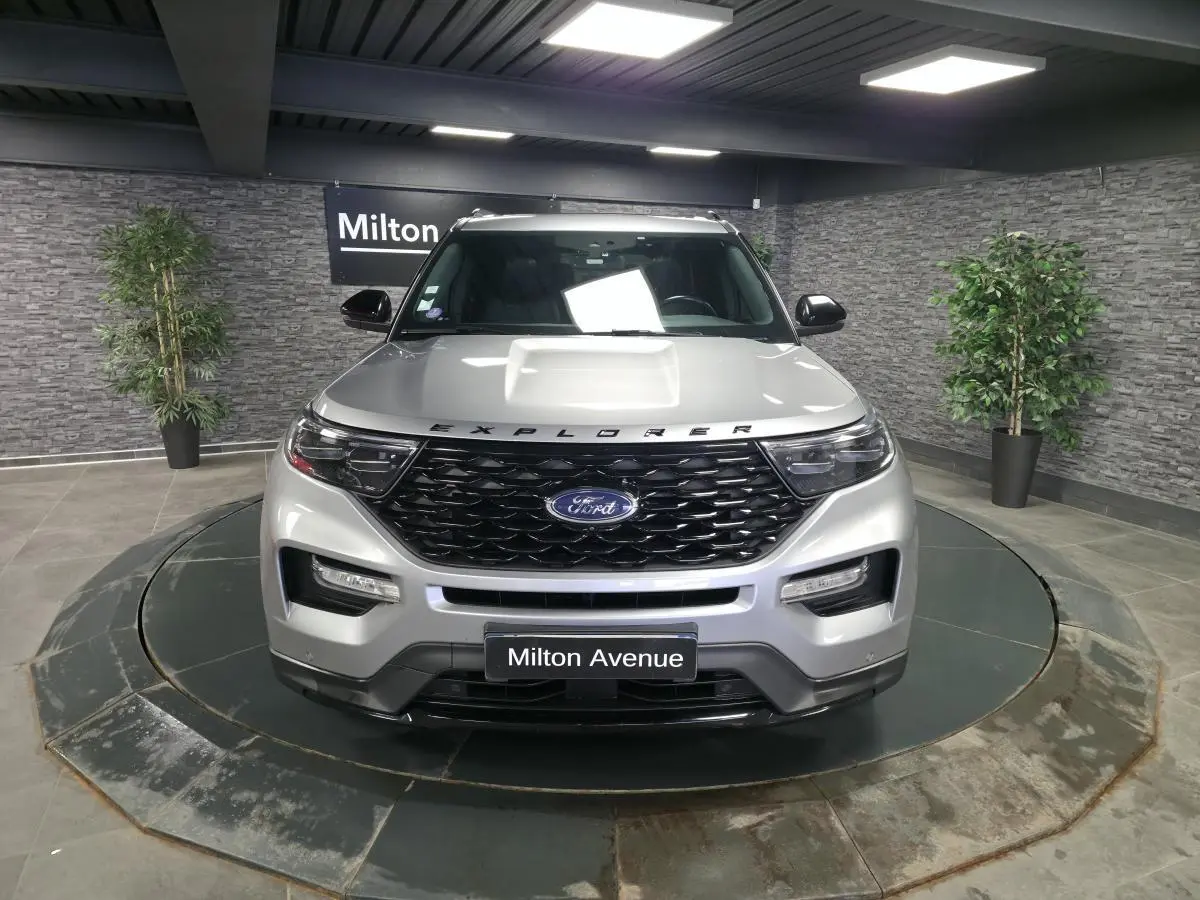 Vue avant d'un Ford Explorer gris métallisé avec calandre noire brillante et inscription Explorer sur le capot.