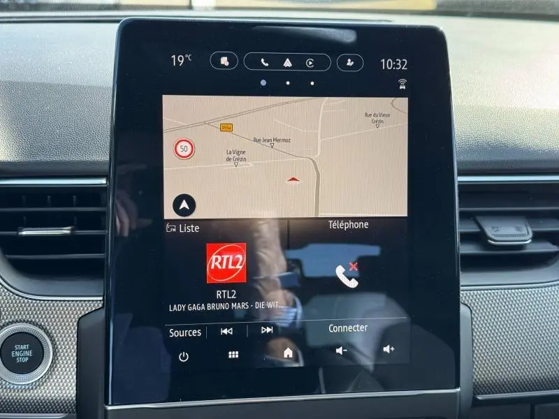 Écran tactile central du tableau de bord du Renault Arkana noir métal, affichant GPS et radio RTL2.