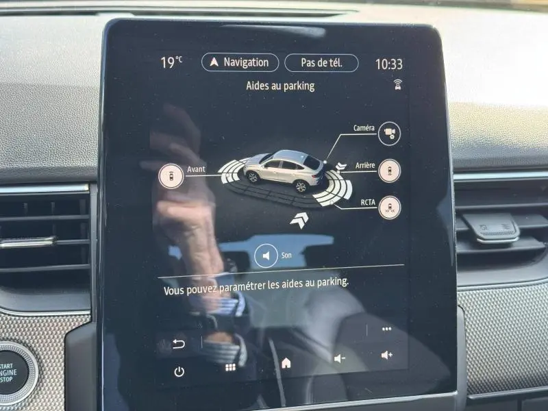 Écran tactile intérieur du Renault Arkana noir métal 2023 montrant l'assistance au parking en vue centrale.
