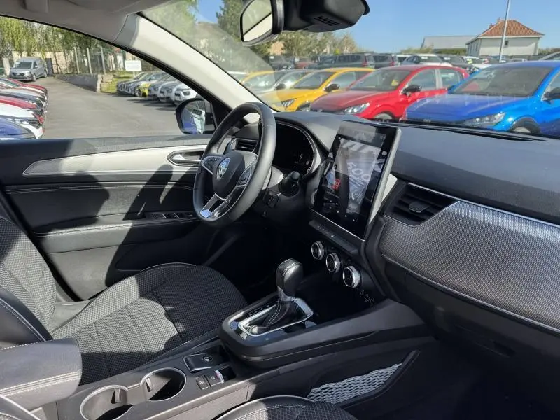 Vue intérieure côté conducteur de la Renault Arkana 1.6 E-Tech 2023, avec tableau de bord moderne et écran tactile vertical.