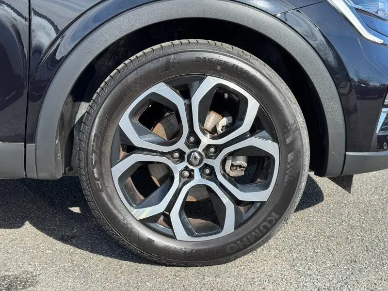 Gros plan sur la roue avant gauche du Renault Arkana noir métal 2023 avec jante alu au design moderne.