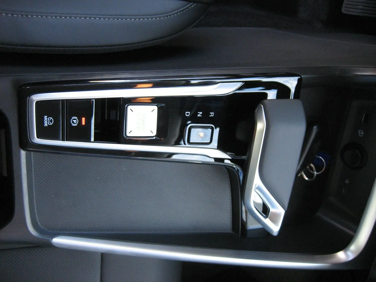 Vue rapprochée de la console centrale noire brillante avec levier de vitesse automatique du MG ZS blanc hybride 2026.