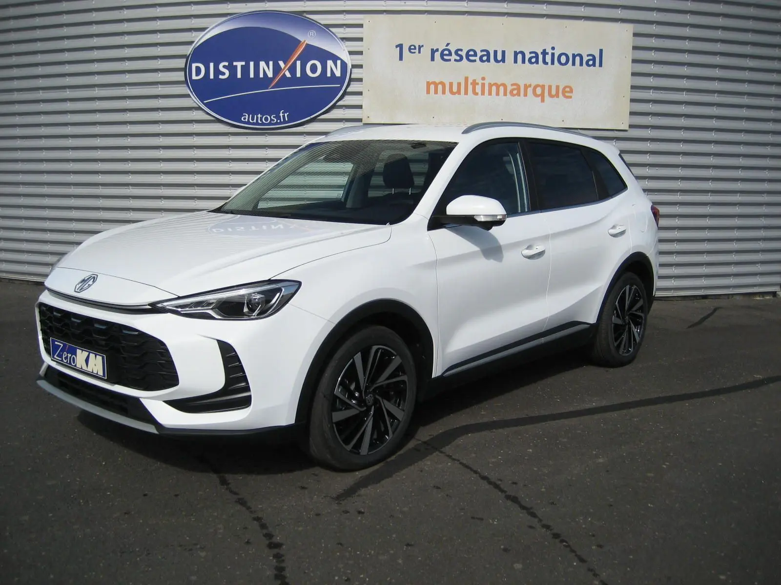 Vue 3/4 avant droite d'un MG ZS blanc 2026 avec jantes noires et calandre noire distinctive.