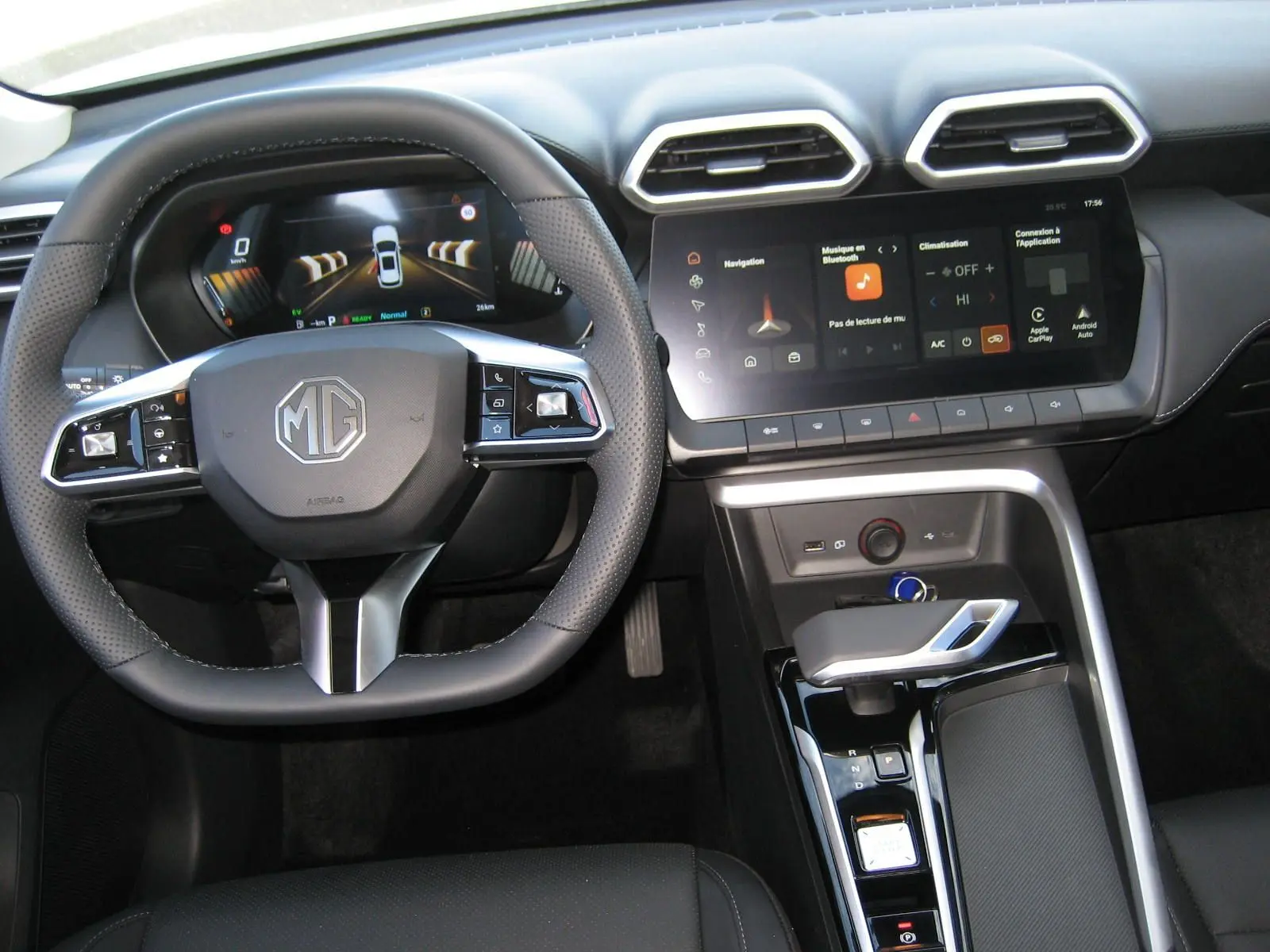 Vue intérieure centrée sur le volant et la console centrale du MG ZS blanc, avec écran tactile et commandes modernes.